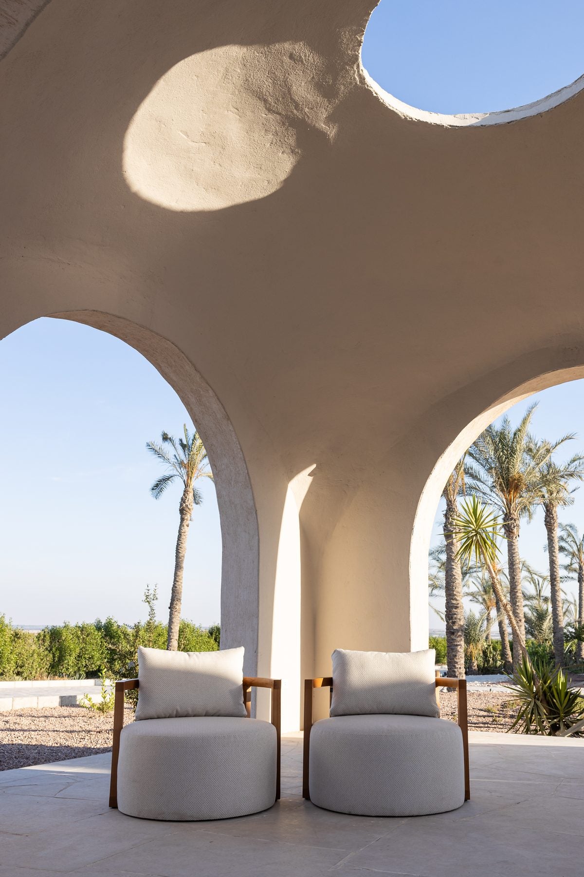 Two Lanott armchairs beneath arched openings