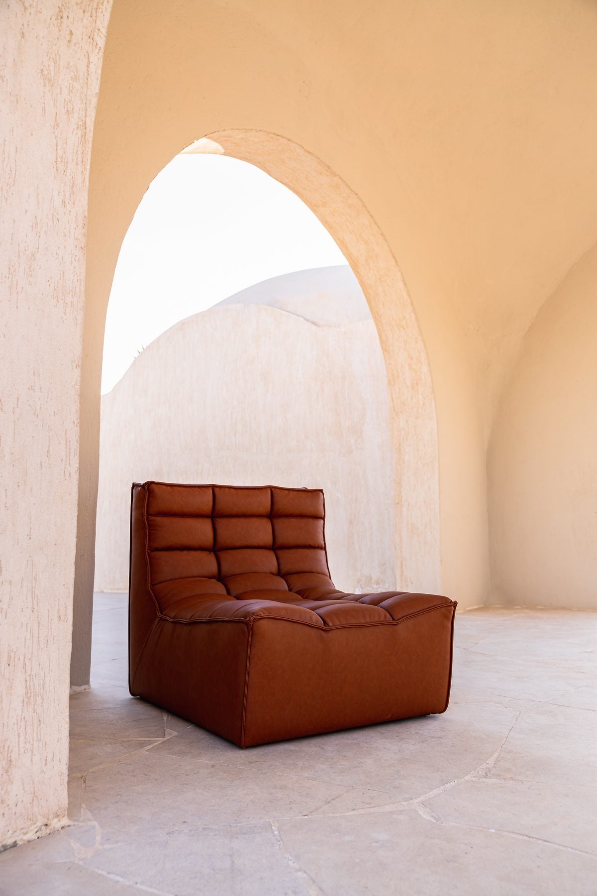 Lanott tan leather chair inside a sunlit arch