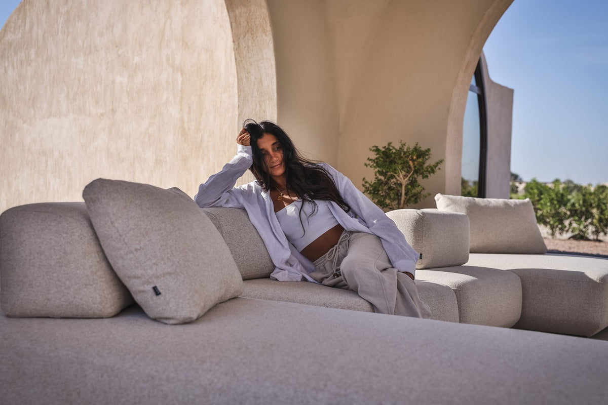 A guest lounging on a Lanott grey outdoor sofa