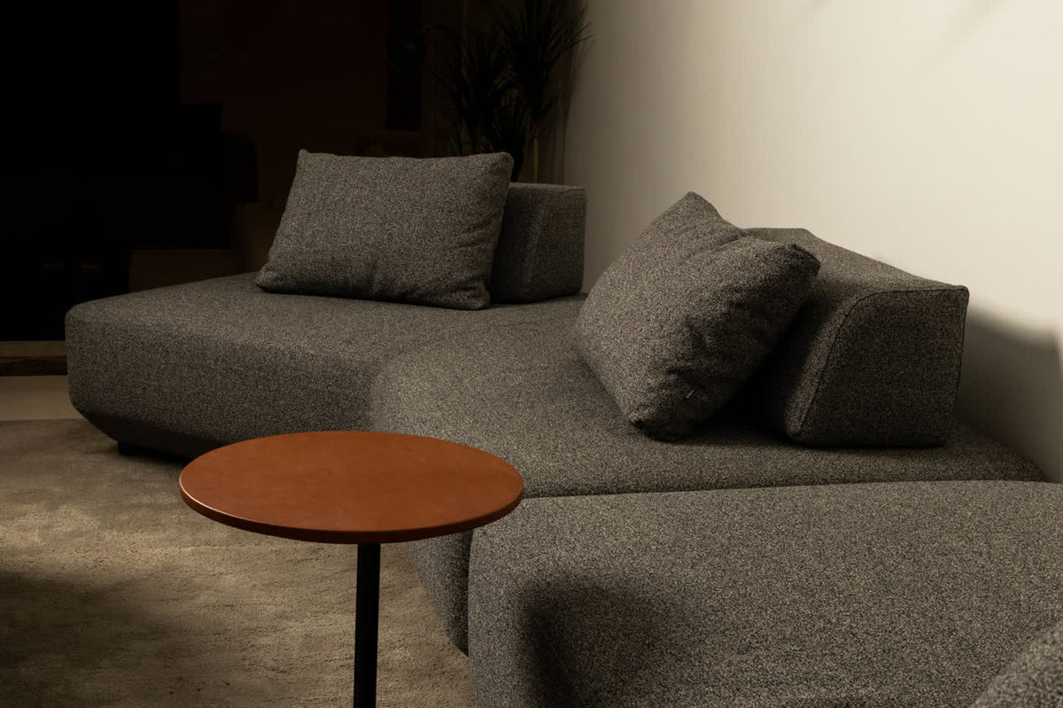 Dark modular sofa with a round side table