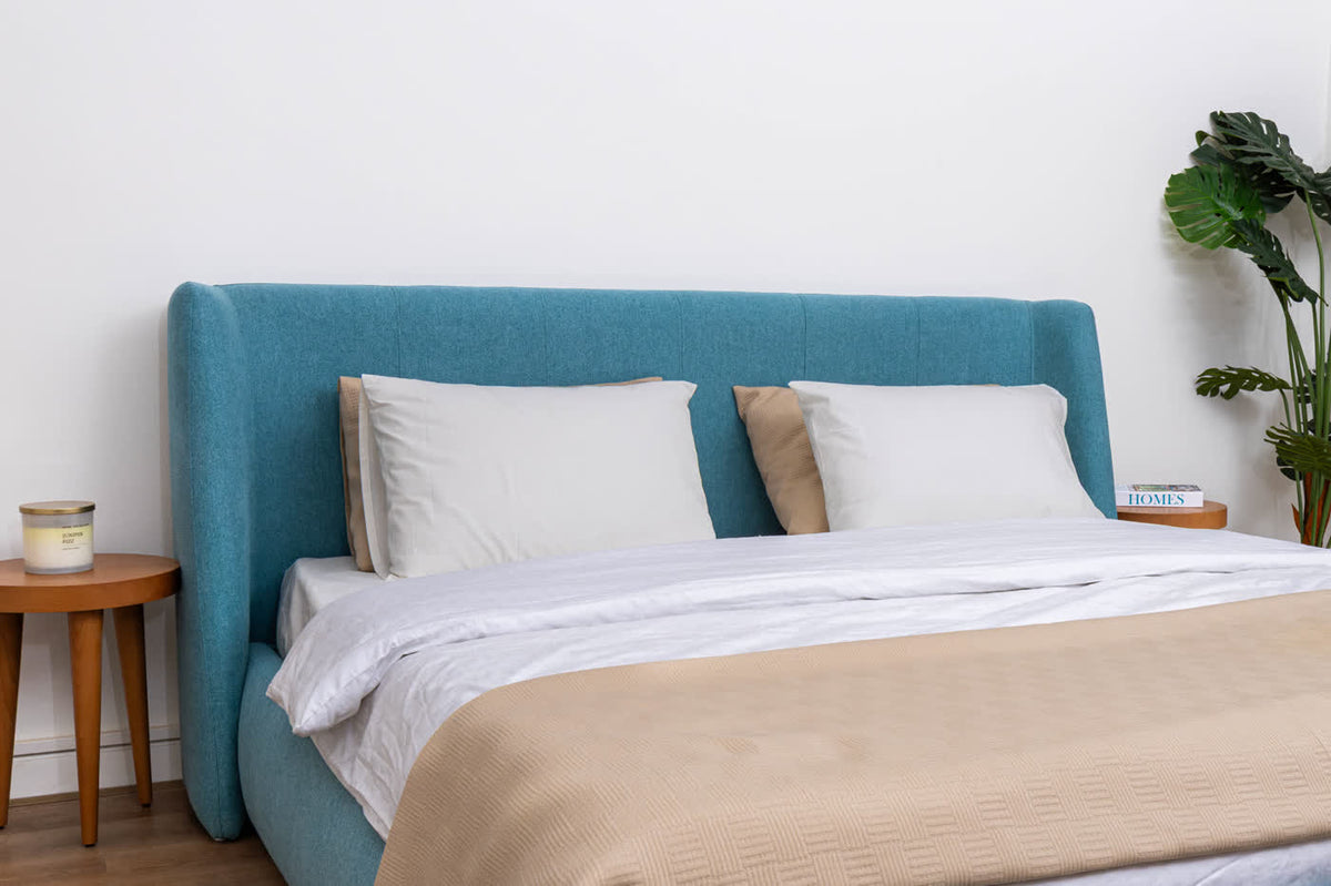 Teal upholstered bed with side tables