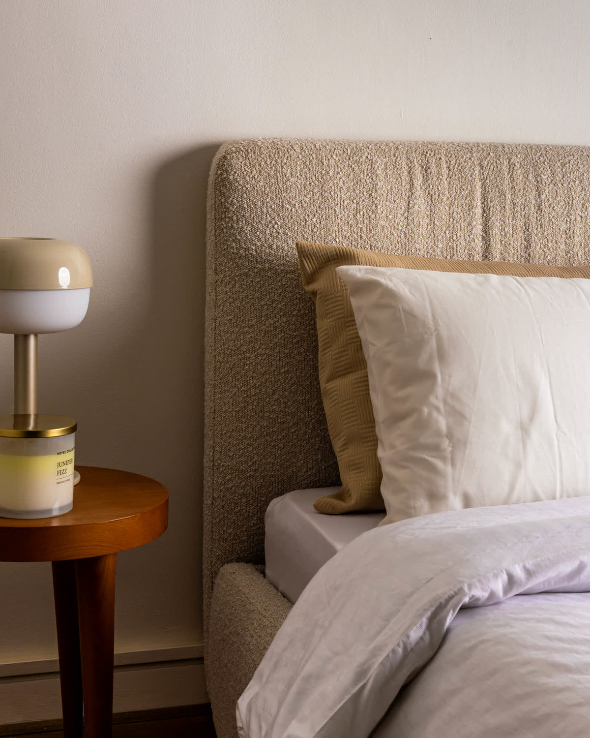 Boucle headboard detail with bedside lamp