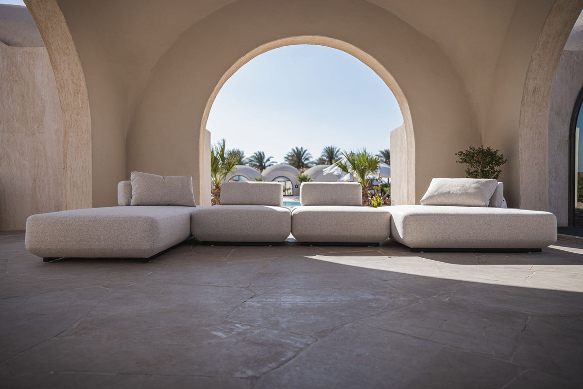 Lanott modular outdoor sofa in a sunlit arched courtyard